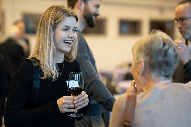 Women and men talking and drinking wine at the 2024 Crozier Lenten Retreat