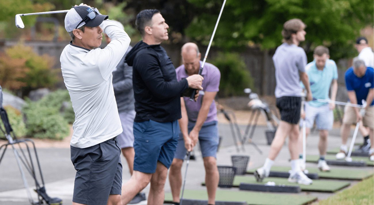 People hitting golf balls at a driving range