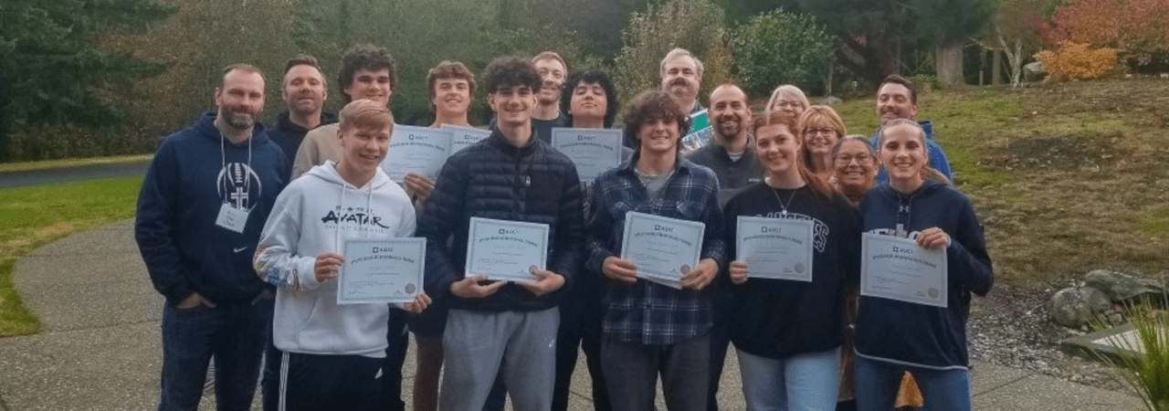 high school students holding mental health program certifications posing for a photo